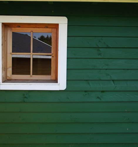 Building with green siding and a small square window