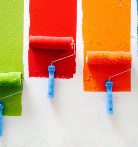 Green, red, orange, and blue paint rollers