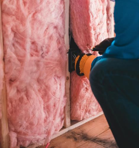 man putting insulation in a wall