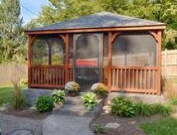 Brown wood rectangle gazebo in residential backyard