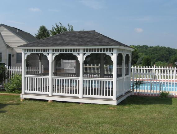 White rectangle wooden gazebo in residential backyard