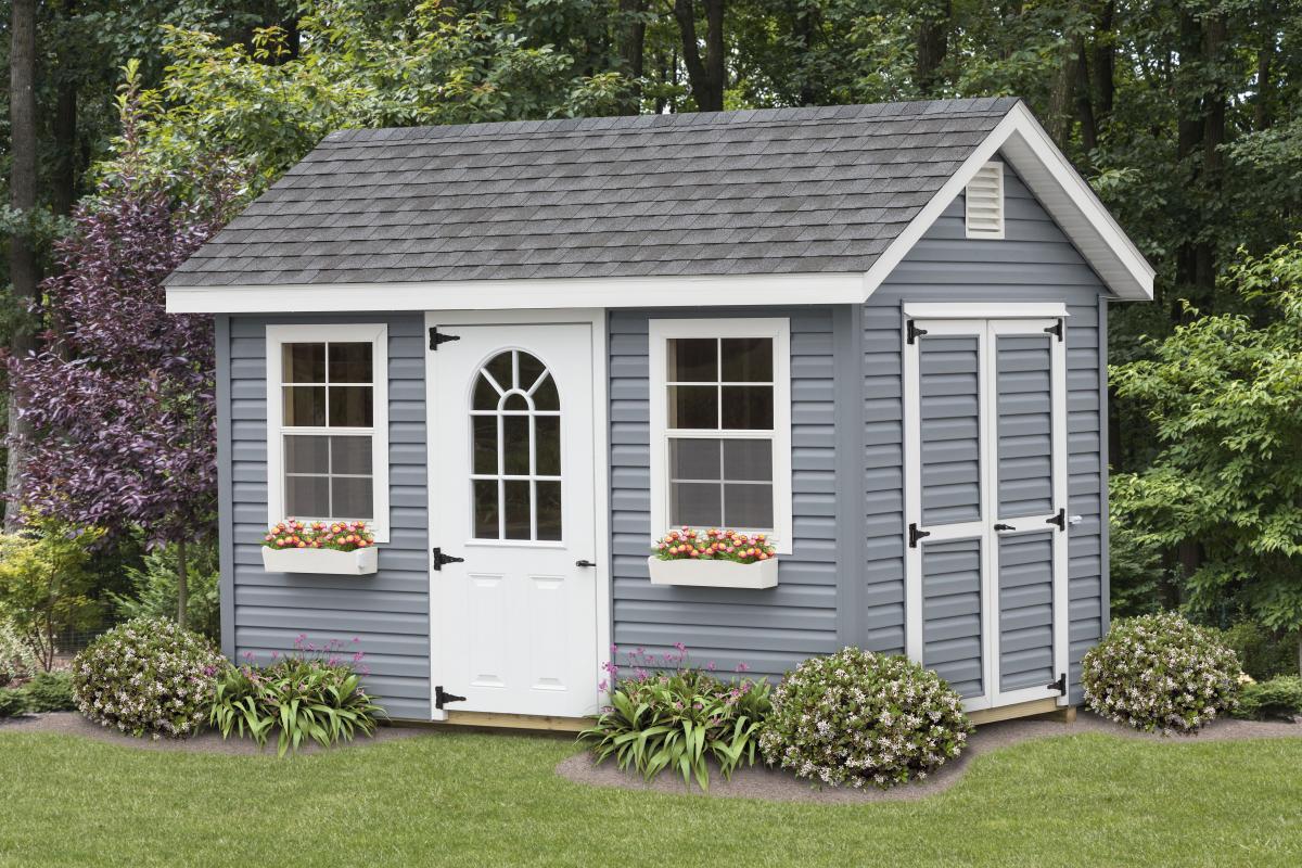 Classic cottage shed in gray with white windows and trim