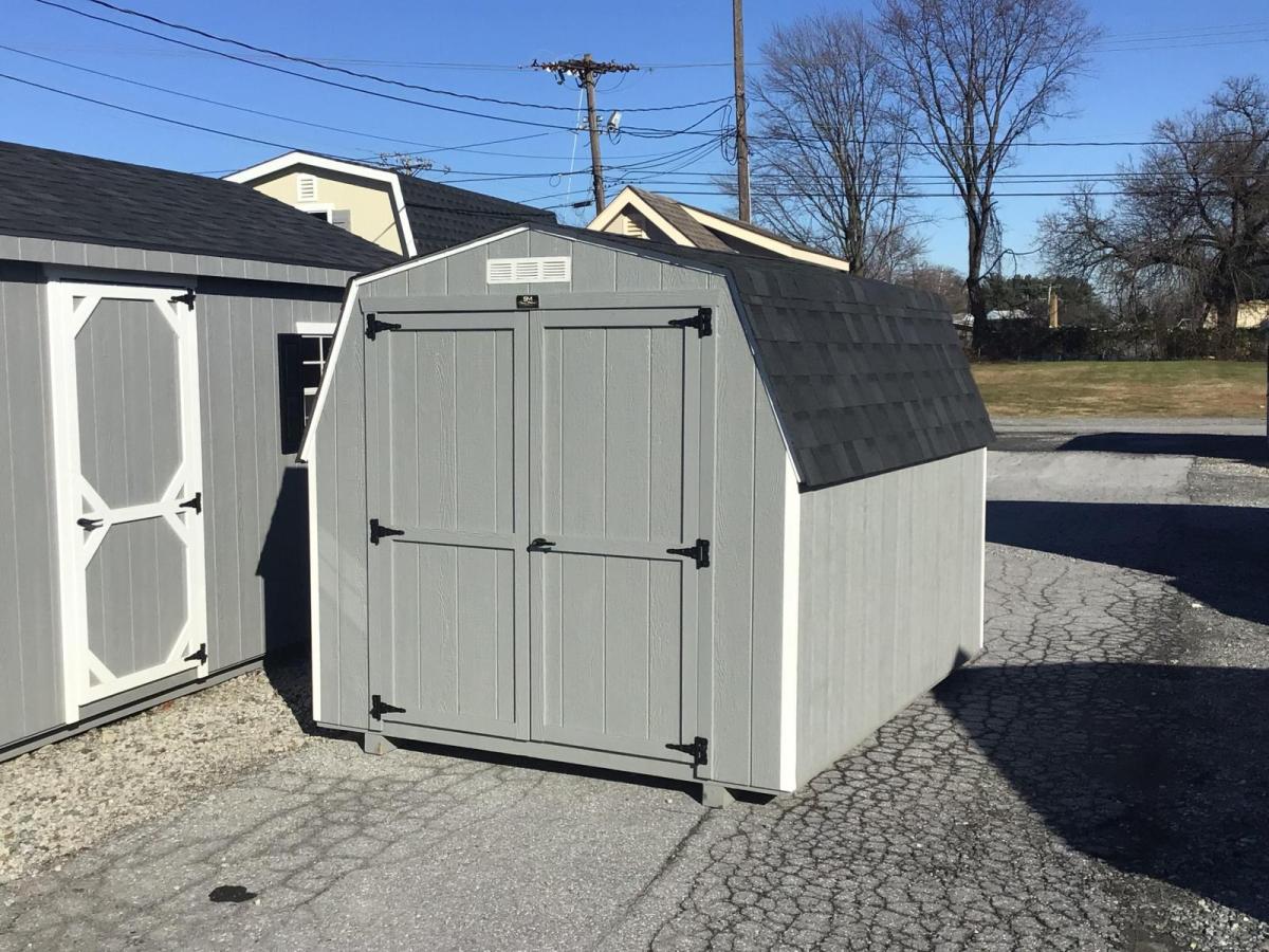 Light gray Newport Shed with white trim, a set of double doors, and a black asphalt roof.