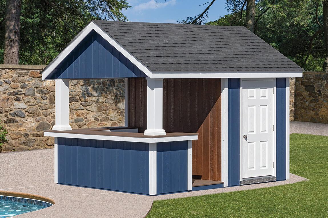 A-Frame Cabana with navy blue wood siding, white trim, a single white door, gray asphalt roofing, white pillars, and brown wood siding behind the counter
