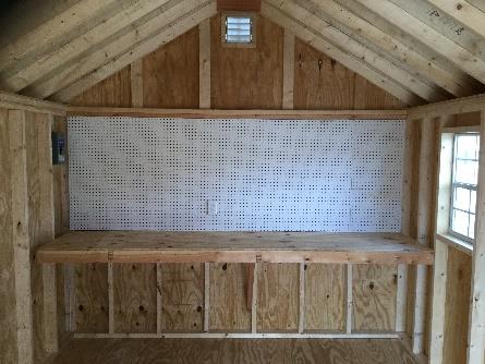 The interior of a Space Makers Sheds' shed with a pegboard spanning the width of the end wall.
