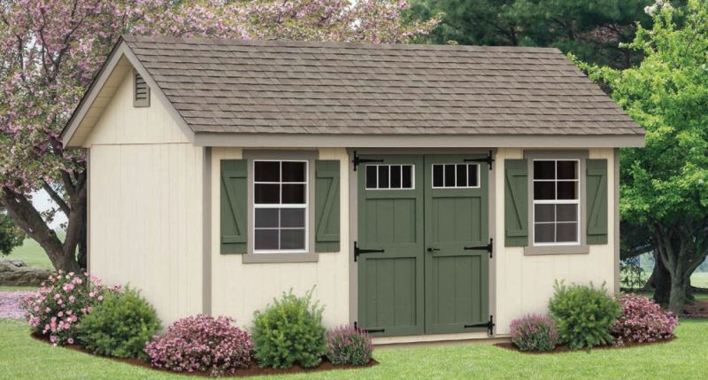 Tan shed with green trim in a residential area